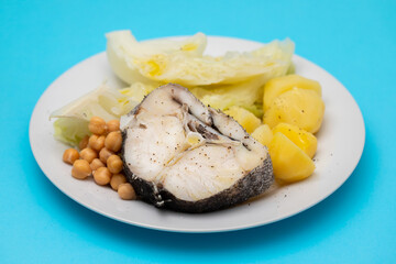 baked vegetables with boiled fish on white plate