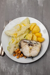 baked vegetables with boiled fish on white plate