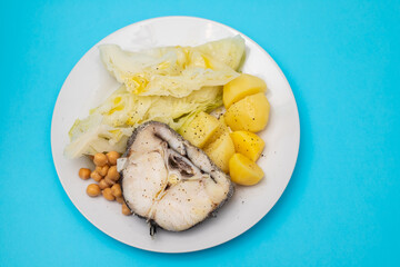 baked vegetables with boiled fish on white plate