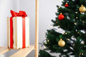 Gift box and Christmas tree, blurred background