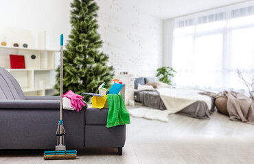 Cleaning before Christmas. Multicolored cleaning supplies. Sponges, rags and spray with festive...