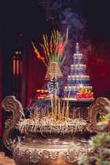 Vertical shot of a Buddhist temple altar with burning incense and religious decorations in Vietnam