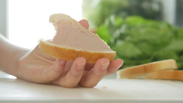 Child Eating Sandwich at Breakfast, Kid Hand with Liver Pate Cream Spread on Slice Bread, Hungry Girl Bites Snacks in Kitchen