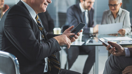 business colleagues using their smartphones during a work meeting