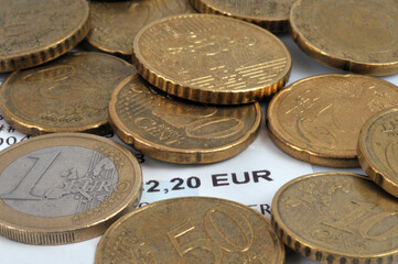 Addition de deux euros entourée de pièces de monnaie