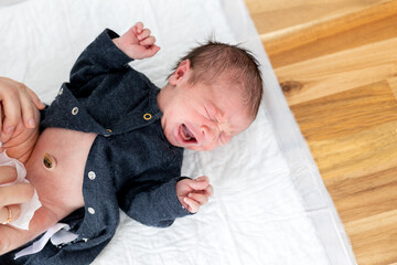 Newborn baby child crying during changing diaper