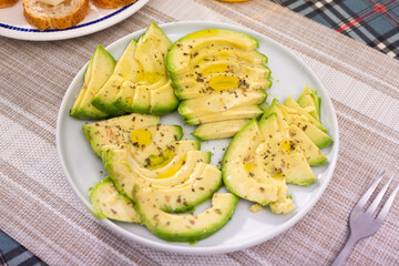 ripe avocado pulp cut into pieces sprinkled with lemon juice on a plate