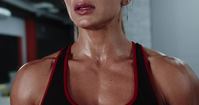 Athletic woman breathes intensively after a strong workout in the gym