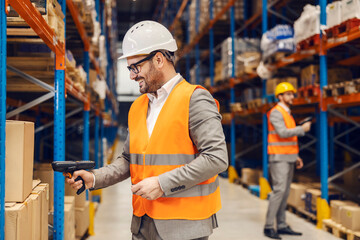 A supervisors load bar codes from boxes and goods in warehouse.