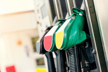 Colorful petrol and diesel nozzles of the dispenser machine at the gas fuel station