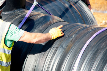 Attenuation tank made of big diameter plastic pipe delivered on construction site, offloaded and...