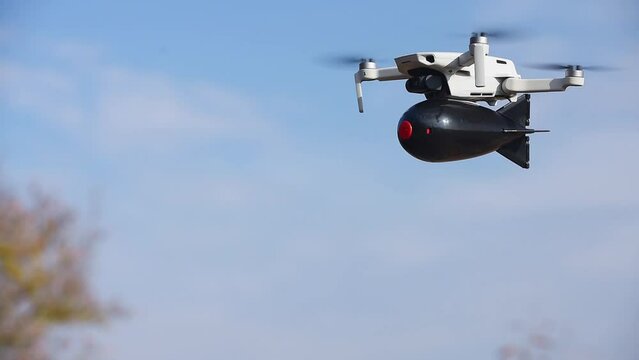consumer civilian drone with a big bomb on board flies in the blue sky