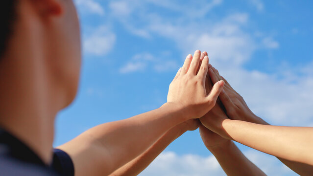 Team work together showing team strength, hands of multiracial people gathered volunteers Teamwork concept for business team success together.