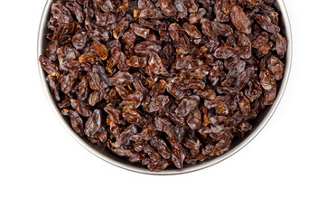 Dark-colored raisins lying in a metal container, shot on a white background.