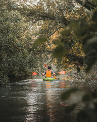 two friends having fun paddling their canoe down a river