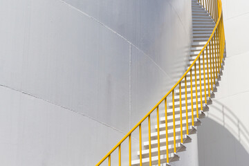 white fuel tank container, white steel petroleum silo and white steel stair with yellow metal handrail. - obrazy, fototapety, plakaty