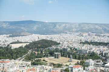 Fototapeta na wymiar Athens, Greece. Acropolis and Parthenon temple, landmark. Ancient remains scenic view from Lycabettus Hill. Urban cityscape, blue sea and sky background