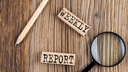 WEEKLY REPORT words on wooden building blocks on the wooden background
