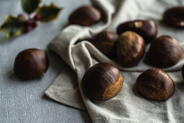 Step by step process of making roasted chestnuts. Heap of raw chestnuts on linen cloth.