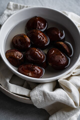 Step by step process of making roasted chestnuts. Chestnuts soaked in water before baking.