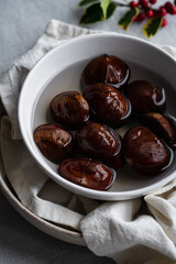 Step by step process of making roasted chestnuts. Chestnuts soaked in water before baking.