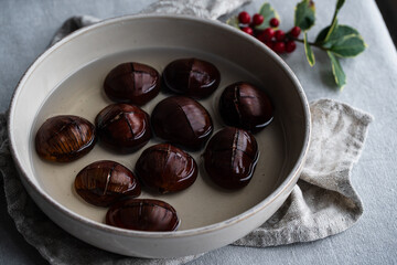 Step by step process of making roasted chestnuts. Chestnuts soaked in water before baking.