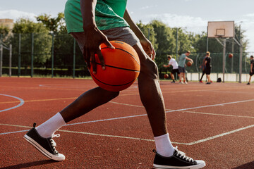 Close up shot selective photo african american basketball player holding ball in hands playing shot in motion at court.