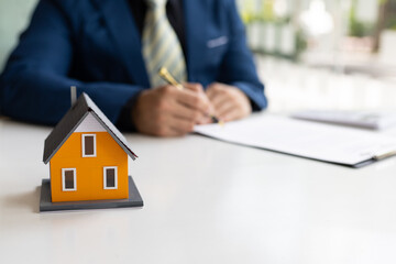 Businessman or real estate agent signs a contract to sell the house legally. Real estate consultant, legal agreement contract, rental, lease, mortgage.