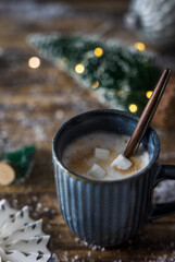 Eine Tasse Kakao mit Marshmellows und Weihnachtsdekroation auf einem rustikalen Holz Tisch. Nahaufnahme.