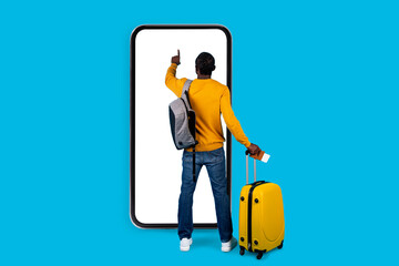 African american man traveller standing by huge smatphone, touching screen