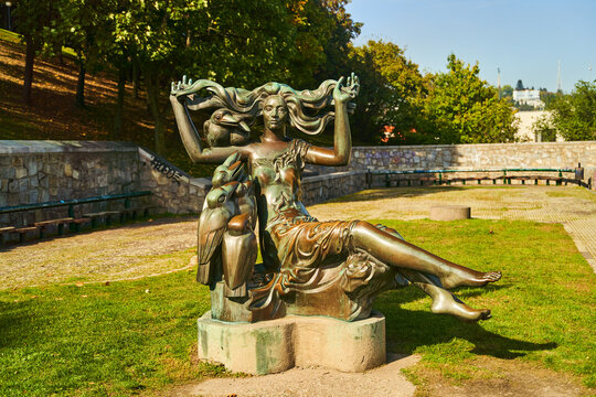 Slovakia, Bratislava - October 8, 2022: A Witch sculpture in Bratislava. A woman statue with birds in park. High quality photo