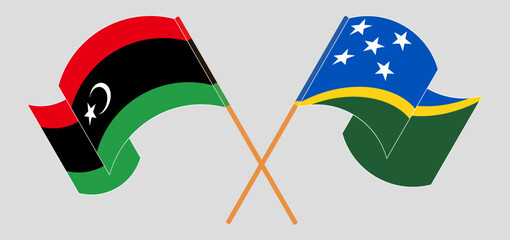 Crossed and waving flags of Libya and Solomon Islands