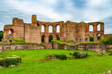 Picturesque close-up view of the remains of the Roman bath complex in the archaeological park of the famous Trier Imperial Baths (Kaiserthermen) in Trier, Germany, on a cloudy day. - obrazy, fototapety, plakaty