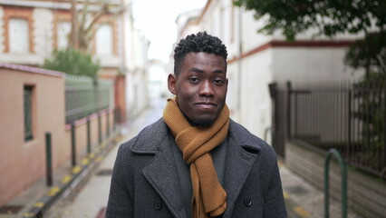 Obraz premium Confident black man walking in city during winter season, person walks forward looking at camera