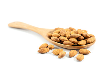 Almonds in a wooden ladle and placed on a white floor, selective focus.