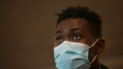 Commuter black man wearing covid-19 face mask going up the electric staircase