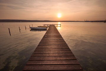 Landscape photo of a jetty and boats on lake at sunset in Varna, Bulgaria. - obrazy, fototapety, plakaty