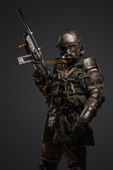 Fototapeta premium Studio shot of military man in spirit of post apocalypse with shotgun staring at camera.