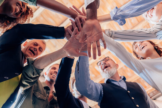 team of diverse people in it as one - group of businesspeople joining their hands in solidarity - stacking hands concept - stock photo