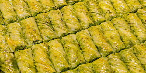 Fototapeta na wymiar Traditional Turkish dessert, pistachio baklava. Turkish style baklava presentation. Baklava from Turkish cuisine, pastry with nuts and honey