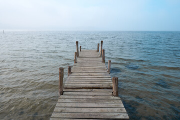 Wooden jetty on lake in a foggy mood.