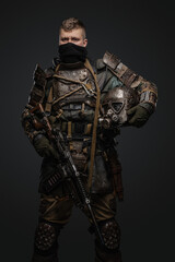 Fototapeta na wymiar Studio shot of isolated on grey background military man dressed in armor holding shotgun.