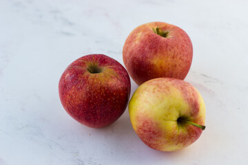 Red-yellow apples on a white marble table