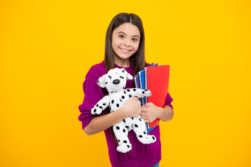 Funny school girl with toy isolated on yellow background. Happy childhood and kids education.