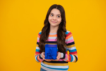 Happy teenager, positive and smiling emotions of teen girl. Child 12-14 years old with gift on isolated background. Birthday, holiday concept. Teenager hold present box.