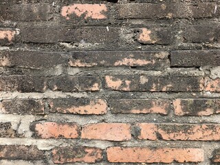 The remains of red bricks used in construction are old, damaged and deteriorated over time. There are mold and dirt stains.
