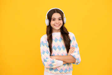 Stylish teenage girl listening to music with headphones. Kids lifestyle concept. Wireless earphones.