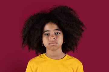 Portrait of curly black child over colorful background