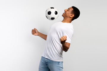 Young man guy football player in white shirt playing ball isolated on white background