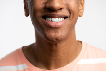 Cropped view of young smiling latin man posing with toothy smile isolated on white background